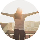 Picture of woman with her arms streached out wide while the sun is rising